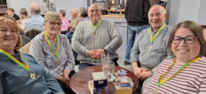 The 5 members of the winning Quiz Night team with big smiles and first place medallions