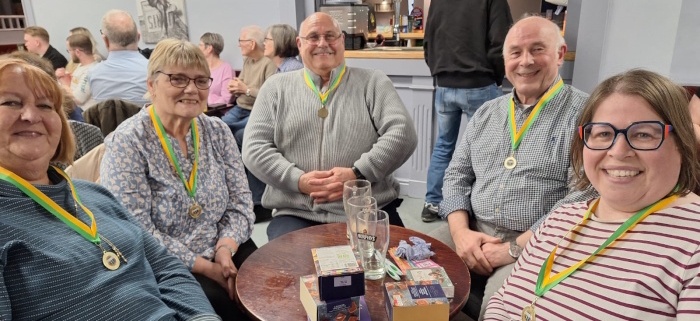 The 5 members of the winning Quiz Night team with big smiles and first place medallions