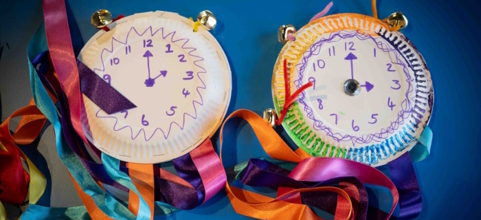 Paper plates with hand-drawn clock faces and colourful ribbons